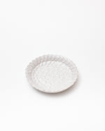 White textured ceramic plate on a white background