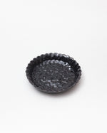 Black textured ceramic dish on a white background