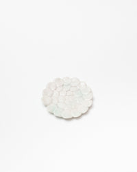 Round white stone coaster on a light beige background