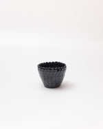 Black textured ceramic cup on a white background
