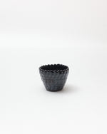 Black textured ceramic cup on a white background