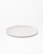 White textured oval platter on a white background
