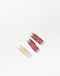 Three lip balm tubes from F. Miller on a white background