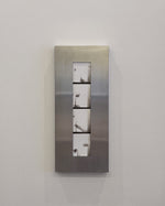 Metallic wall frame with four rectangular panels on a white wall