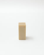 Beige rectangular bar of soap on a white background