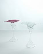 Two clear martini glasses on a white background