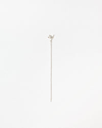 A delicate silver stick with a small leaf-shaped top, photographed vertically against a clean, solid white background.