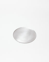 A minimalist, round silver tray with a brushed metal finish, centered on a clean white background.