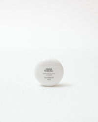 White skincare product container with text on a white background