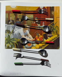 Fork and spoon set displayed on a page of a book, featuring artistic background of a dining scene