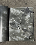 Metallic star-shaped objects on a textured surface