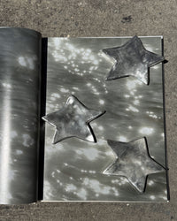 Metallic star-shaped objects on a textured surface